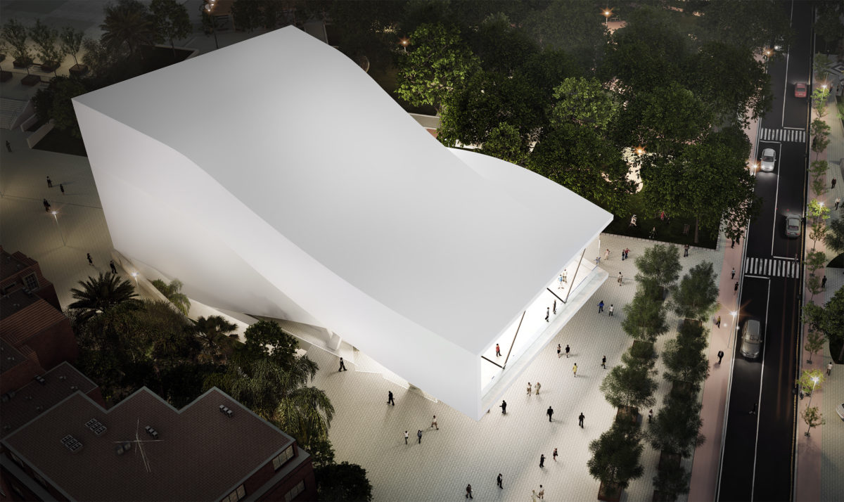 AQSO arquitectos office. A bird's eye view shows the sinuous shape of the auditorium roof. This white concrete building has a folded shape that contrasts with the vegetation of the urban park.