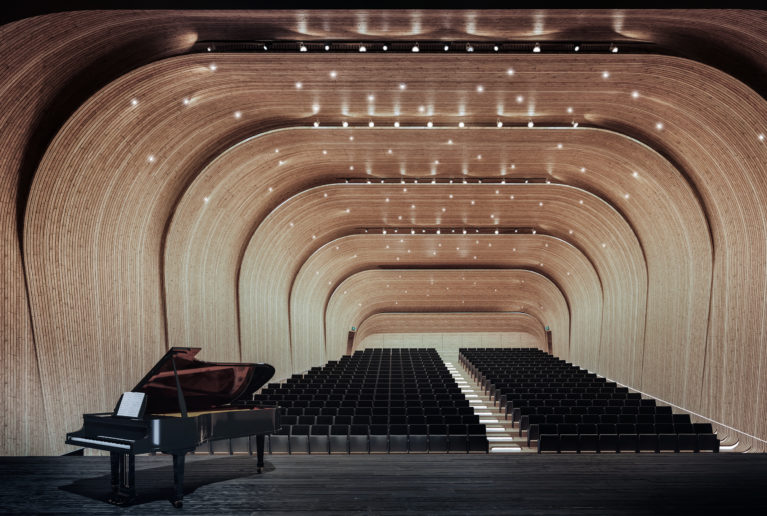AQSO arquitectos office, auditorio sin doblez, iluminación de la sala, techo con estrellas, cascarón de madera, envolvente acústica, cintas de madera superpuestas, vista desde el escenario, salida de emergencia
