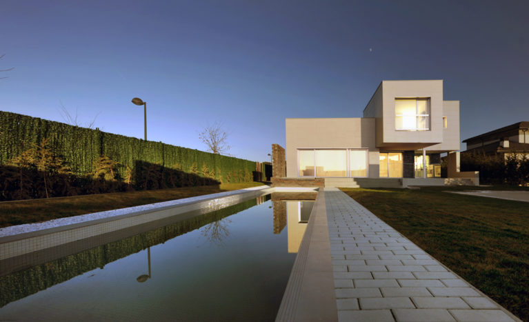 AQSO arquitectos office. La vivienda cuenta con una piscina de natación alargada en el jardín delantero considerada una de las mejores de España.