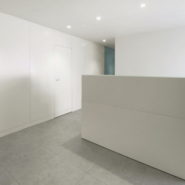 AQSO arquitectos office. La clínica Zurbarán tiene un mostrador de madera lacada en color blanco en la sala de consultas del dentista. Es un diseño interior simple y minimalista de color blanco.