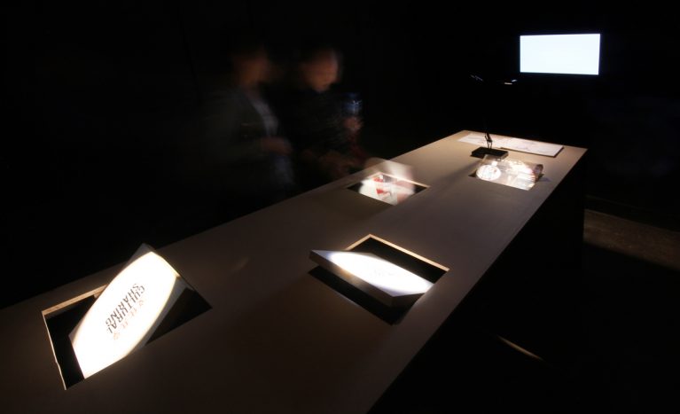 AQSO arquitectos office. Las mesas de la exposición tienen paneles giratorios que permiten al público interactuar con el contenido y descubrir la información y las imágenes de los proyectos.