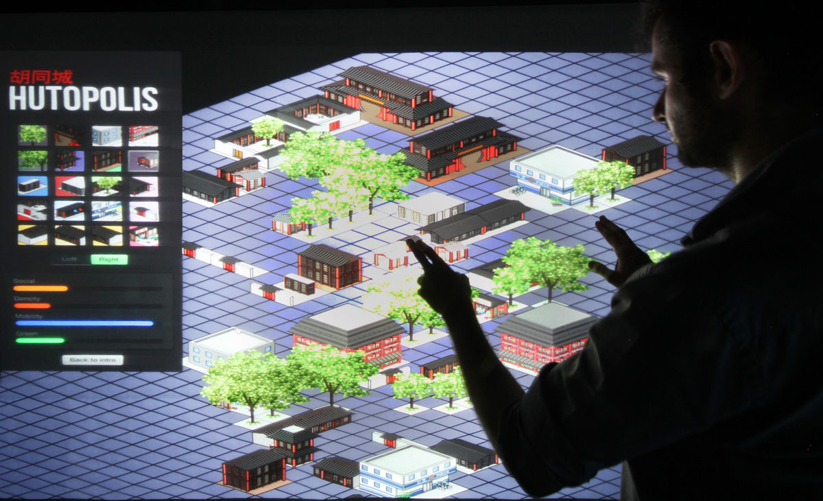 AQSO arquitectos office. Una pantalla táctil de gran tamaño permite a los visitantes de la exposición interactuar con los parámetros urbanos de los hutong y comprender el equilibrio y diversidad del barrio.