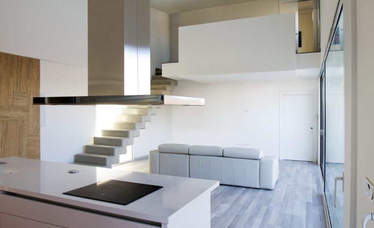 AQSO aquitectos office. The kitchen, living room and dining room are located on the ground floor, from where a concrete staircase leads up to the bedrooms.