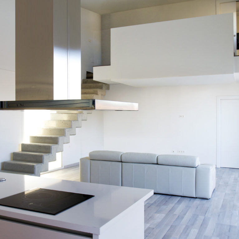 AQSO aquitectos office. The kitchen, living room and dining room are located on the ground floor, from where a concrete staircase leads up to the bedrooms.