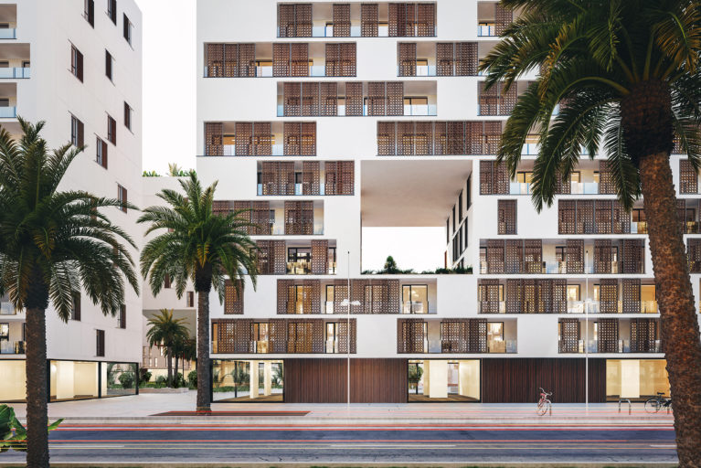 AQSO arquitectos office, residencial anfa. La vista frontal del alzado muestra los balcones con paneles correderos de tracería de madera inspirados en juegos geométricos marroquís, que forman una piel siempre cambiante..