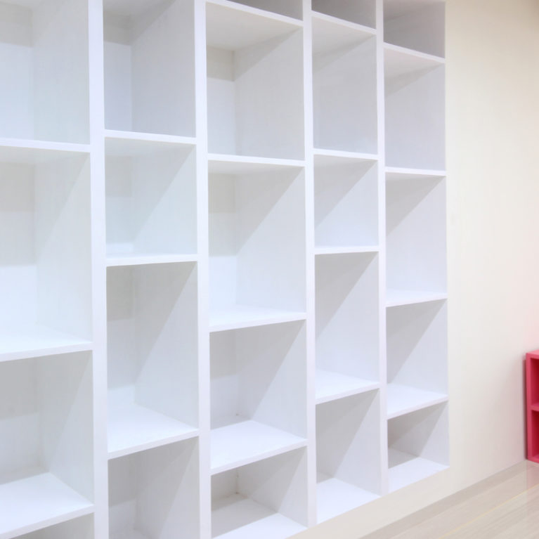 AQSO arquitectos office. La librería blanca hecha a medida y empotrada en la pared tiene un diseño original y funcional, con estanterías a diferente altura, creando un ritmo de huecos.