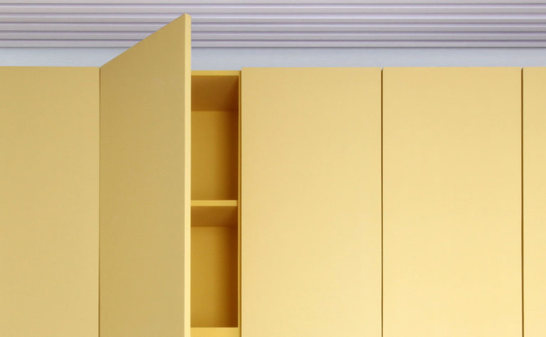 AQSO arquitectos office. The furniture in this school management centre is made of colourful lacquered wood. They are simple and functional cupboards with concealed handles and hinges.
