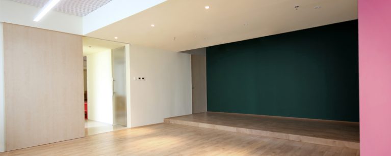 AQSO arquitectos office. The multifunctional room of this educational management centre has a sliding door and a blackboard wall.