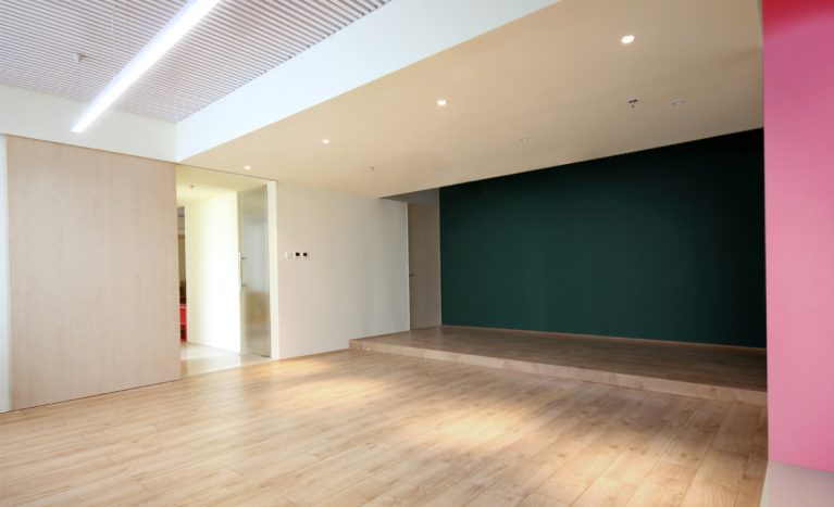 AQSO arquitectos office. La sala multifuncional de este centro de gestión educativa cuenta con una puerta corredera y una pared de pizarra.