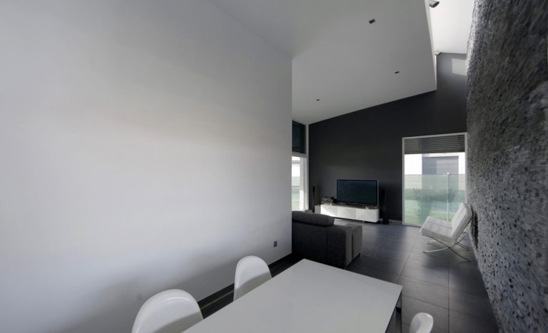 AQSO arquitectos office. The dining room is a transition space to the living room in this open-plan flat. The space is illuminated by the skylight in the ceiling and the large windows facing the garden.