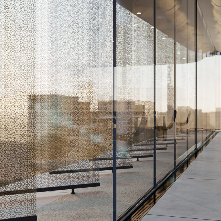 AQSO arquitectos office. Lamas de vidrio laminado con malla metálica de motivos arabescos vista desde el interior de las oficinas.