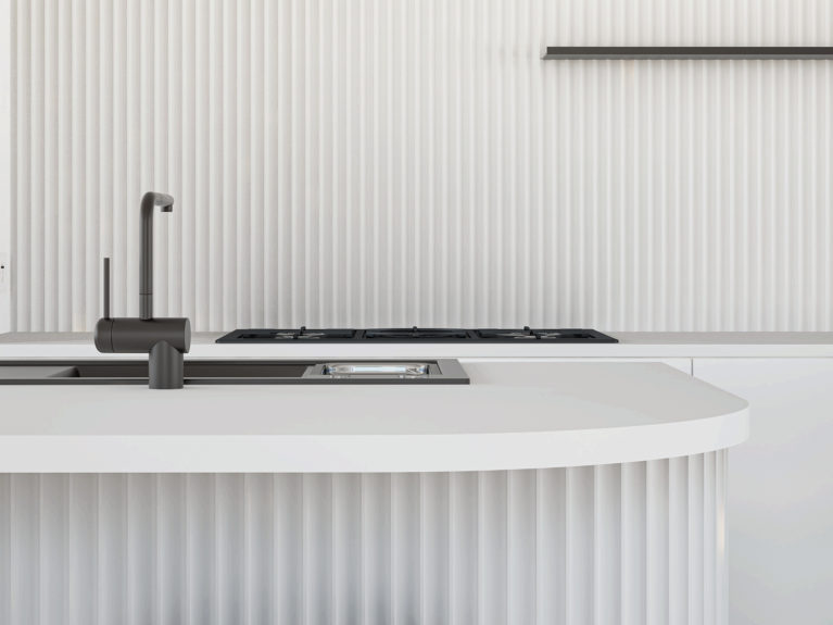 AQSO arquitectos office. Detail of the kitchen island, with vertical ceramic tile walls and minimalist matt black mixer tap.