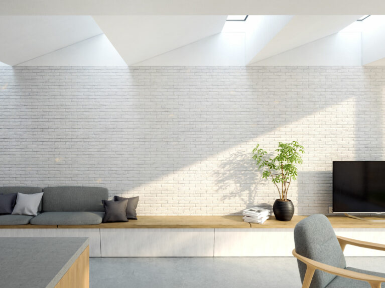 AQSO arquitectos office. Along the white-painted solid brick wall sits a comfortable, informal wooden bench that doubles as a sofa and sideboard.